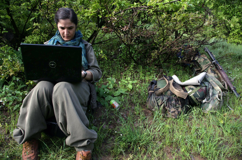 A female Kurdistan Workers' Party (PKK) fighter works on her laptop after arriving in the northern Iraqi city of Dohuk on May 14, 2013, after leaving Turkey as part of a peace drive with Ankara. The PKK has fought a 29-year nationalist campaign against Ankara in which some 45,000 people have died, but is now withdrawing its fighters from Turkey as part of a push for peace with the Turkish authorities. AFP PHOTO/SAFIN HAMED